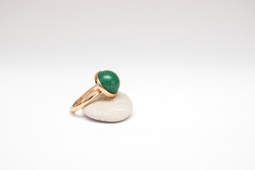 Vintage gold ring with green stone on gray pebbles