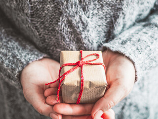 Frau hält ein Geschenk Paket mit roter Schleife in den Händen. Weihnachten.