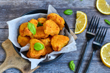 
 Crispy  deep fried home made    chicken strips Breaded  with  almond flour chicken  breast fillets  with chilly peppers and fresh   basil on wooden rustic background. Ketogenic diet food