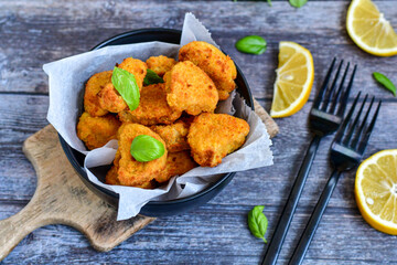 
 Crispy  deep fried home made    chicken strips Breaded  with  almond flour chicken  breast fillets  with chilly peppers and fresh   basil on wooden rustic background. Ketogenic diet food