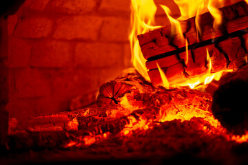 Burning log of wood in a fireplace close-up.