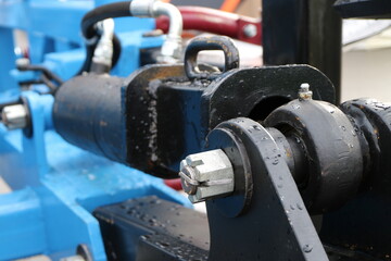Black hydraulic cylinder on the blue frame.