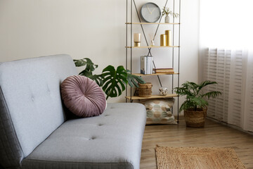 Minimalistic image, beige textile couch with round cushions and floor shelf over the blank wall background with a lot of copy space for text. Empty room interior with just a single sofa. Close up.