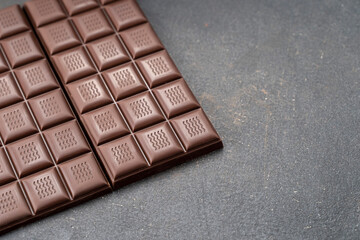 Handmade chocolate bar copy space. Black bitter craft chocolate on white background. Healthy food...