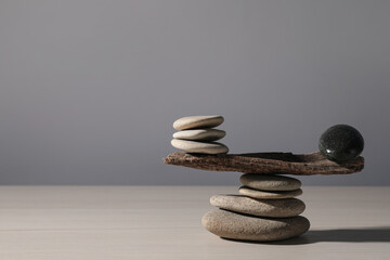 Stack of stones with tree branch on wooden table, space for text. Harmony and balance concept - obrazy, fototapety, plakaty