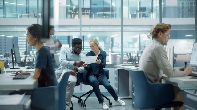 Diverse Team of Managers Working and Having Discussions in Modern Big City Office. Colleagues Work on New Business Opportunities, Evaluate Financial Reports, Plan Investment Strategy.