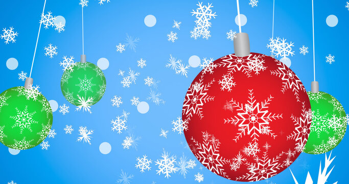 Image of snow falling over christmas baubles