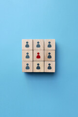 Wooden cubes with drawings of small people. A symbol of a team of specialists led by a leader. 