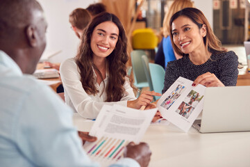 Group Of Business Colleagues Having Informal Meeting Around Table In Office Coffee Shop