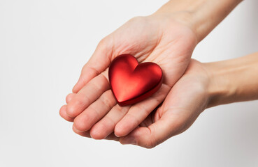 Hands holding red heart, close-up, white background