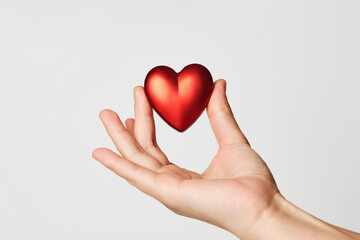 Obraz premium Hands holding red heart, close-up, white background