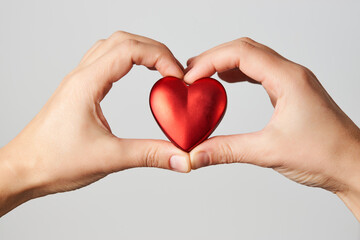 Obraz premium Hands holding red heart, close-up, white background