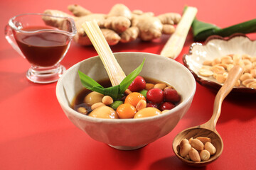 Wedang Ronde (Tangyuan) or Glutinous Sweet Balls Dumpling in Ginger Infused Palm Sugar Syrup. Topping with Roasted Peanuts. Copy Space