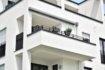 Moderne Betonbalkone mit beschichtetem Metall-Geländer und Attika-Blech als Mauerschutz an...