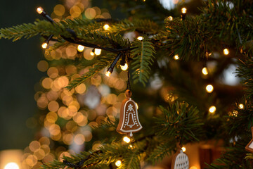 Christmas gingerbread decoration on a Christmas tree on golden bokeh background