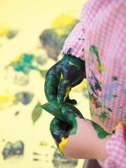 Close up on a kids hand painting with colorful watercolors