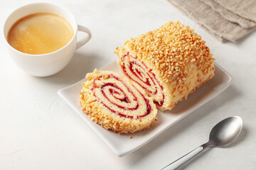 Sweet biscuit roll with strawberry jam and nuts on the table