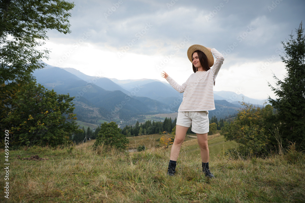 Wall mural young woman enjoying her time in mountains. space for text