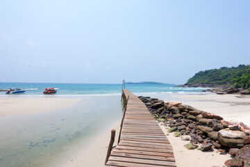 Fototapeta premium Wooden bridge, corridor to the sea on Beautiful crystal clear sea and tropical beach at tropical paradise island, Thailand