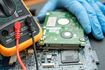 technician repairing inside of hard disk by soldering iron. Integrated Circuit. the concept of...