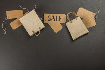 Black Friday Sale concept. Shopping paper bags, handmade tags. Black stone concrete background
