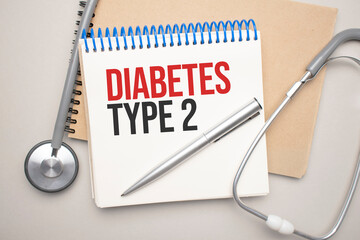 White notepad with the words diabetes type 2 and a stethoscope on a blue background. Medical concept
