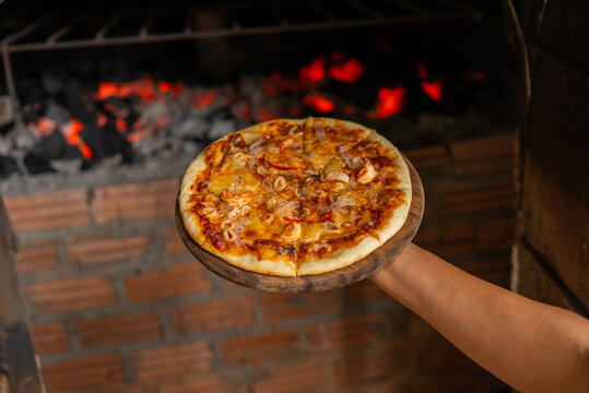 Hand Holding Pizza Tray Coming Out Of Oven