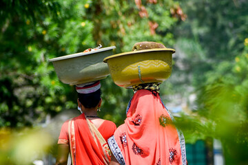 Asian Woman carrying vegetables in head for sell 