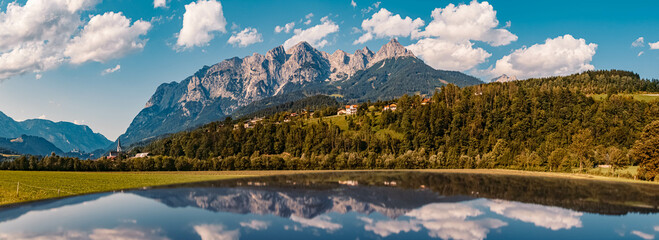 High resolution stitched panorama of a beautiful alpine summer view with reflections on a car roof and the famous Tennengebirge mountains in the background near Pfarrwerfen, Salzburg, Austria - obrazy, fototapety, plakaty
