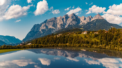 High resolution stitched panorama of a beautiful alpine summer view with reflections on a car roof and the famous Tennengebirge mountains in the background near Pfarrwerfen, Salzburg, Austria - obrazy, fototapety, plakaty