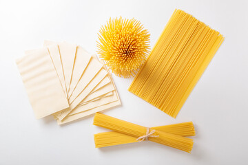 A vertical bunch and a bunch of raw spaghetti tied with string. Bundle on a white background. View...