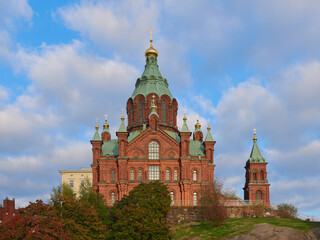 Orthodox Uspensky Cathedral in Helsinki: katajanokka, autumn, red brick, old historic building, stone, blue beautiful sky.
