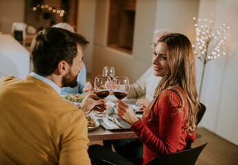 Happy family having dinner with red wine at home