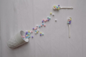 Creative composition on white textured background. Concept of positive emotions, think positive. pills for happiness. Top view of colourful scattered confetti.