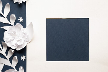 White frame with paper flowers on blue background