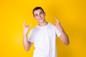 A handsome guy in a white t-shirt  gesticulating on a yellow background