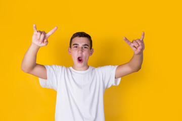 A handsome guy in a white t-shirt  gesticulating on a yellow background