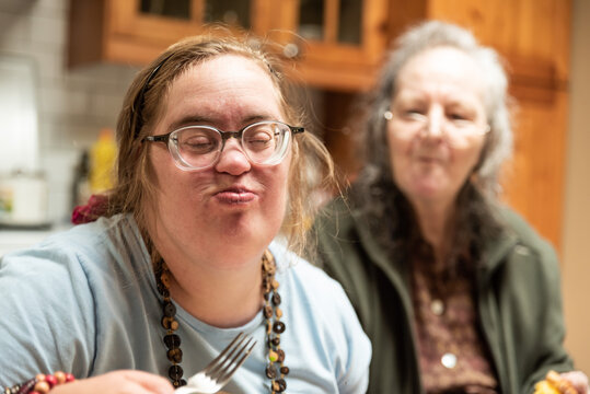 Hakendover, Flemish Brabant, Belgium - 09 20 2021: Disabled 39 year old woman and her 83 year old mother having fun in the kitchen at home