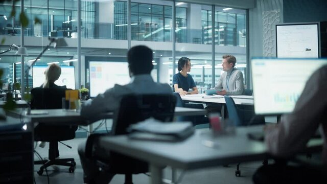 Diverse Team of Managers Working and Having Discussions in Modern Big City Office. Colleagues Work on New Business Opportunities, CEO Having Meeting with Employee, Talking About Investing in Future.