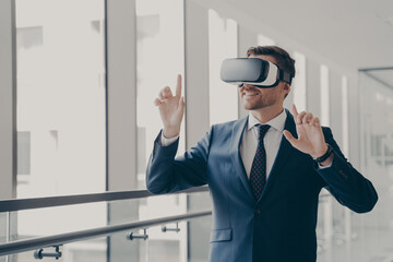 Handsome smiling businessman in vr headset using innovative technologies for business at work