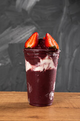 Brazilian Frozen Açai Berry Ice Cream Smoothie in plastic cup with Straw Berries and Condensed...