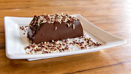 Chocolate pudding with sprinkles, delicious chocolate dessert on wooden table