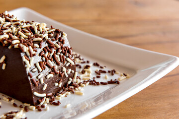 Details of Chocolate pudding with sprinkles, delicious chocolate dessert on wooden table.