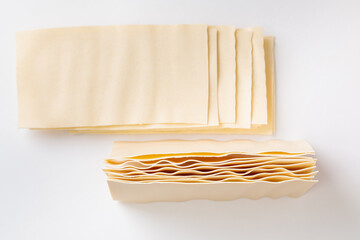 Raw lasagna. Dry dough sheets for lasagna on a white background.