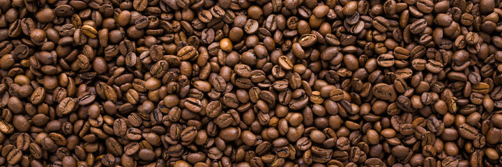 Fresh brown coffee beans background. Closeup. Empty place for text. Wide banner. Top down view.