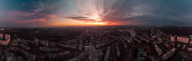 Aerial wide scenic vivid sunset panorama view with epic skyscape. Kharkiv city center, Pavlove pole residential district streets and buildings in evening colored light