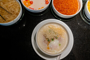White porridge in a ready-to-eat cup with crispy noodles. and soft-boiled eggs