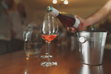 Sommelier pours a glass of rose wine for a tasting.