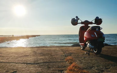 Foto op Plexiglas Rode vintage scooter aan de kust. © M-Production