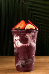 Brazilian Frozen Açai Berry Ice Cream Smoothie in plastic cup with Strawberries, Bananas and...